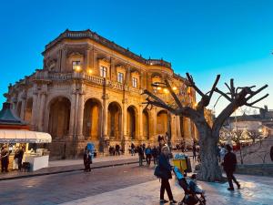 a large building with people walking in front of it at Eureka Apartment in Noto
