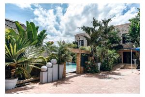 a villa with a swimming pool and palm trees at Leon's Hotel in Choma