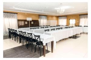 a conference room with white tables and black chairs at Leon's Hotel in Choma +27 photos