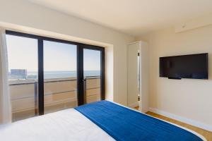 a bedroom with a large bed and a flat screen tv at Guest Favorite Sea View Apartments Batumi in Batumi