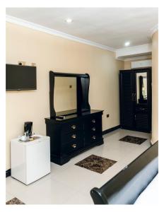 a black dresser with a mirror and a white table at Leon's Hotel in Choma