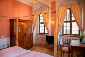 a bedroom with a bed and a desk and a television at Hotel Börse in Görlitz