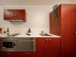 a kitchen with a sink and wooden cabinets at Punthill Narrabundah in Canberra