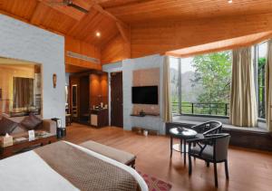 a bedroom with a bed and a living room at Aureva Shaantam Resorts & Spa - Rishikesh in Rishīkesh