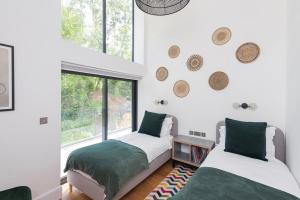 two beds in a room with a window at Bluebell Barn - Cookswood in Holcombe
