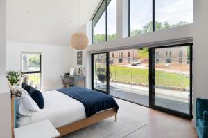 a bedroom with a large bed and large windows at Bluebell Barn - Cookswood in Holcombe +42 photos