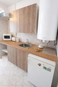 a kitchen with a sink and a white refrigerator at Csopaki promenade in Csopak +6 photos