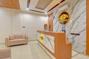 a lobby with a reception desk and a chair at FabHotel New Moshi Grrand in Pune