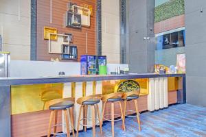 a bar with four stools at a counter at FabHotel New Moshi Grrand in Pune