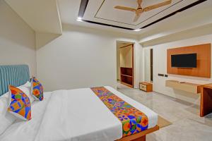 a bedroom with a bed and a television in it at FabHotel New Moshi Grrand in Pune