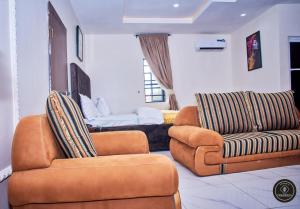 ein Wohnzimmer mit zwei Sesseln und einem Sofa in der Unterkunft Ozigrand Hotel in Benin-Stadt