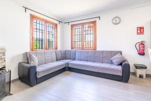 a gray couch in a living room with windows at Villa Els Pins in El Arenal