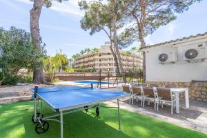 a ping pong table in a yard with chairs at Villa Els Pins in El Arenal