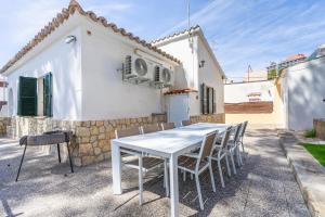 a white table and chairs in front of a house at Villa Els Pins in El Arenal