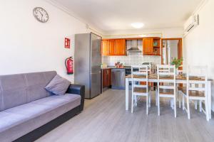 a living room with a couch and a table and a kitchen at Villa Els Pins in El Arenal