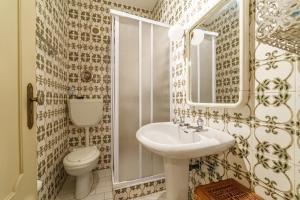 a bathroom with a sink and a toilet and a mirror at Excellent location, good access to the beach in Vila do Conde +11 photos
