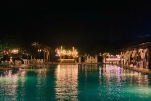 a pool at night with lights in the background at Ana resort Phu Yen in Liên Trì (4)