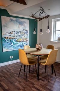 a dining room with a table and chairs and a painting at Art Apartment Sønderbygaard in Vinderup +50 photos