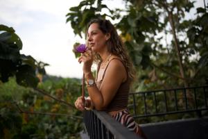 a woman holding a purple flower in her mouth at Sundaras Infinity Jungle Resort & Spa in Dambulla