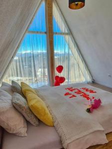 a bedroom with a bed with a large window at Wild Hill Apuseni in Gârda de Sus