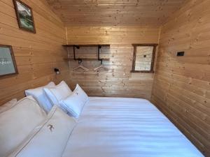 a bedroom with a bed in a wooden room at La Tiny du Clos Ernest in Cheminot