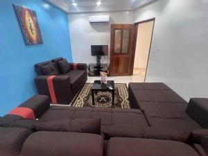 a living room with a couch and a table at MBAO Sipres Appartement moderne bord de mer in Mbaw