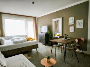 a bedroom with a bed and a desk and a table at Stelo Appartments in Gosau +28 photos