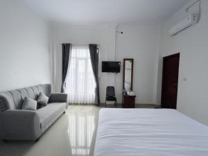 a living room with a bed and a couch at Guest House Primitif in Temon +5 photos