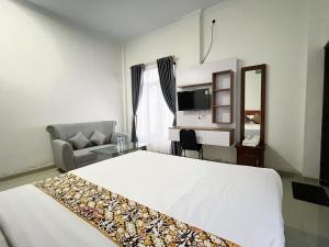 a hotel room with a large white bed and a couch at Guest House Primitif in Temon