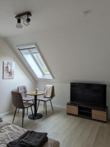 a living room with a tv and a table with chairs at Landhaus Freche Socke in Buchhorst