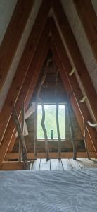 a room with a bed in a attic with a window at La Kabanetik in La Tacherie