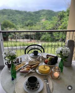 a table with plates of food on top of a balcony at Vila_da_Montanha in Gravatá +15 photos