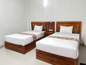 two beds sitting next to each other in a room at Guest House Primitif in Temon