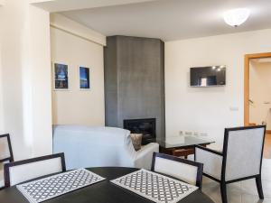 a living room with a table and chairs and a couch at Casa da Estação in Torre de Moncorvo