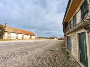 an empty street next to an old building at Casa da Estação in Torre de Moncorvo