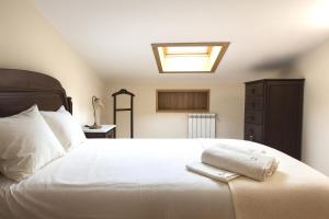 a bedroom with a large white bed with a skylight at Casa da Estação in Torre de Moncorvo