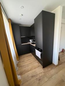a kitchen with black cabinets and a wooden floor at Cozy Apartment In Sigulda in Sigulda