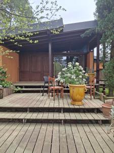 a deck with a table and chairs and a pot of flowers at Maison zen in Laval-Pradel