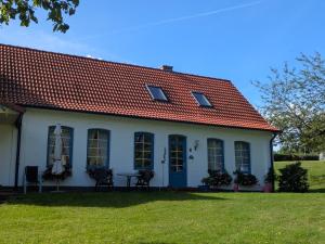a white house with a red roof at Landhaus Freche Socke in Buchhorst