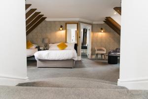 a bedroom with a bed and a chair in a room at Woodlands Hotel in Bartley