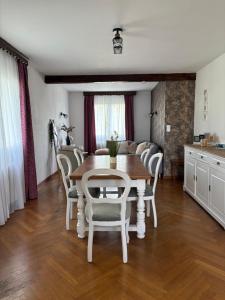 a kitchen and dining room with a table and chairs at Maison chaleureuse de village - location à la chambres in Lanans +12 photos