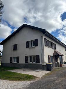 a white house with windows on the side of it at Maison chaleureuse de village - location à la chambres in Lanans