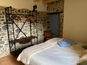 a bedroom with a white bed with a rack on the wall at Mas Casalprim in Sant Feliu de Pallerols