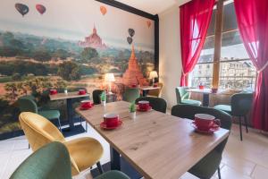 a restaurant with a table and chairs and a mural at Hotel Mondial in Tours
