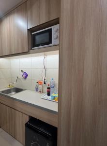 a kitchen with a sink and a microwave at Osaka riverview Apartment PIK 2 by SS in Rawalumpang