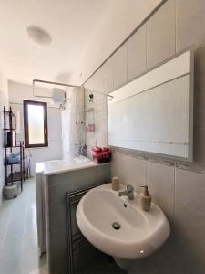 a white bathroom with a sink and a mirror at Villa Colline Fiorite in Putignano