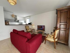 a living room with a red couch and a tv at L'appartement la rochebardière in Saint-Paul-lès-Dax