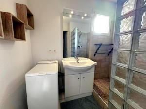 a white bathroom with a sink and a mirror at L'appartement la rochebardière in Saint-Paul-lès-Dax +19 photos