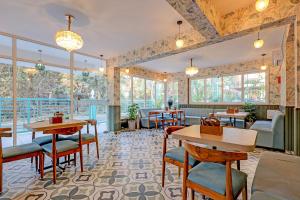 a restaurant with tables and chairs and windows at FabHotel High Five - Nr Vagator Beach in Assagao