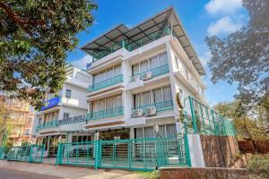 a white building with blue balconies on a street at FabHotel High Five - Nr Vagator Beach in Assagao